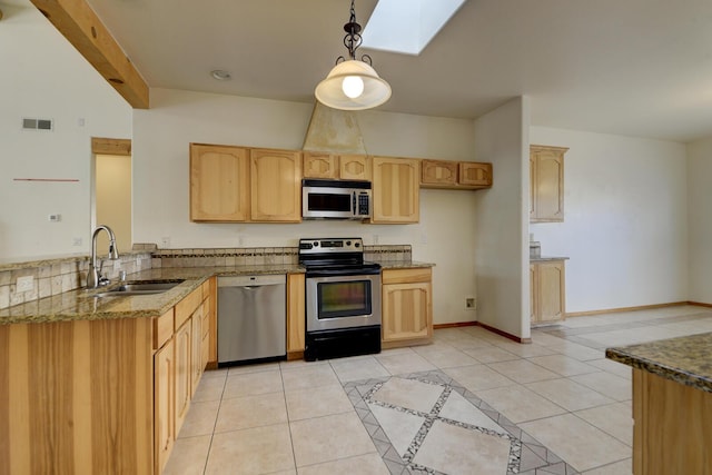 kitchen featuring light brown cabinetry, light tile patterned floors, appliances with stainless steel finishes, and a sink