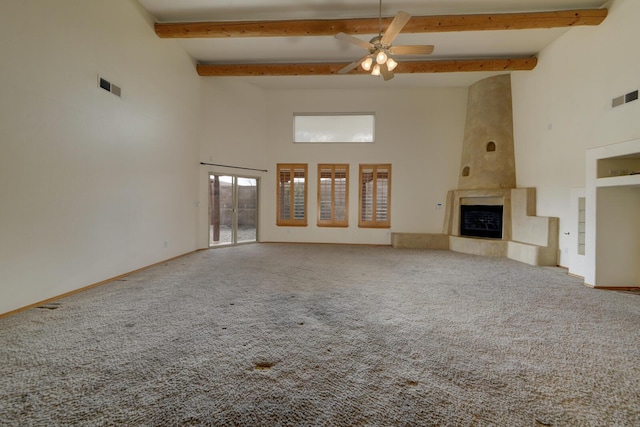 unfurnished living room featuring visible vents, beamed ceiling, a large fireplace, and carpet floors