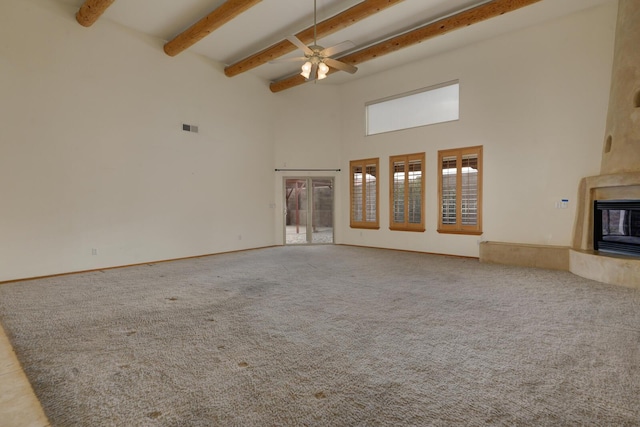 unfurnished living room with beam ceiling, carpet floors, visible vents, and a premium fireplace