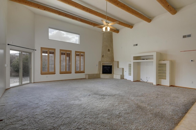 unfurnished living room with visible vents, beam ceiling, a high ceiling, a fireplace, and light carpet