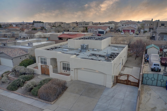 view of front of home featuring a residential view, stucco siding, fence, and a gate