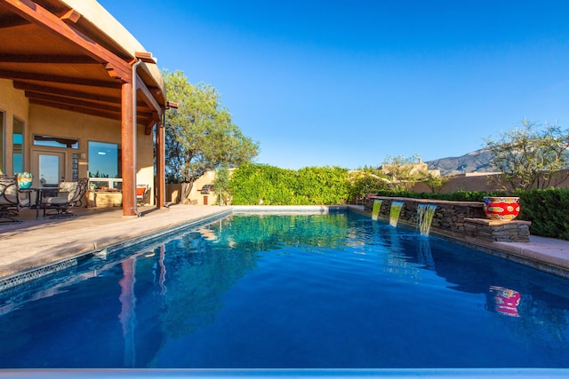 view of swimming pool featuring a patio, a fenced in pool, and a mountain view