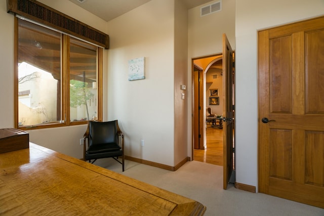 bedroom with visible vents, arched walkways, light colored carpet, and baseboards