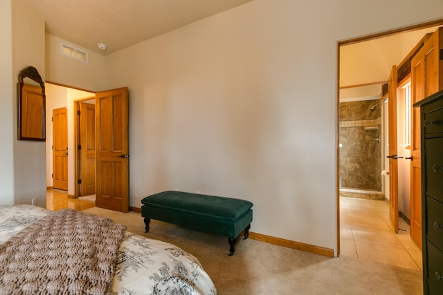 bedroom featuring light tile patterned floors, visible vents, baseboards, ensuite bathroom, and light colored carpet