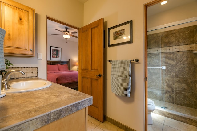 ensuite bathroom with vanity, baseboards, a stall shower, tile patterned floors, and toilet