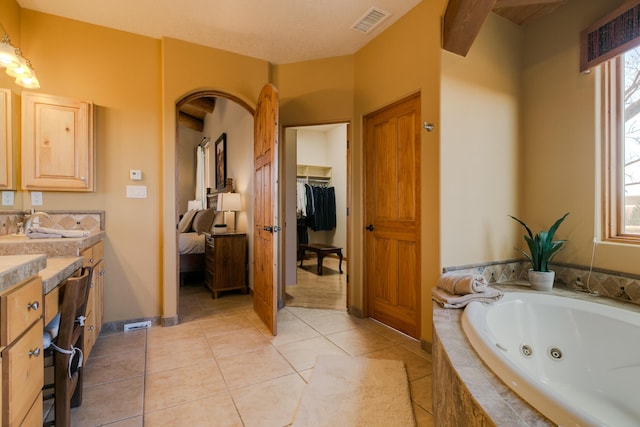 bathroom featuring vanity, tile patterned floors, a jetted tub, and visible vents