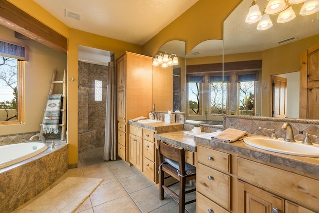 bathroom with double vanity, tiled shower, visible vents, and a sink