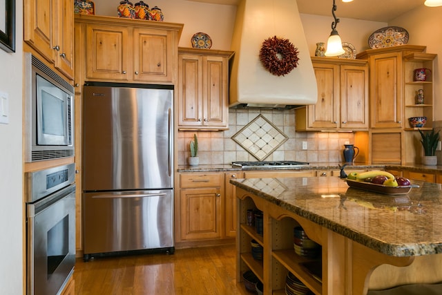 kitchen featuring premium range hood, open shelves, wood finished floors, appliances with stainless steel finishes, and decorative backsplash