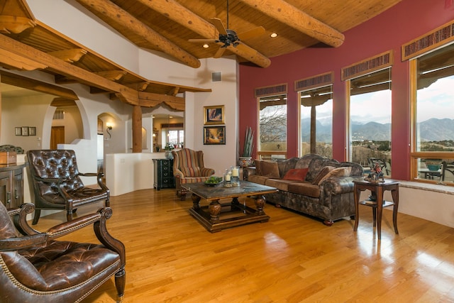 living area with plenty of natural light, a mountain view, wood ceiling, and wood finished floors