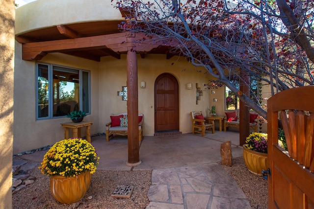 view of exterior entry with a patio area and stucco siding