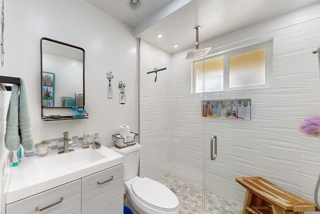 bathroom featuring vanity, a shower stall, and toilet