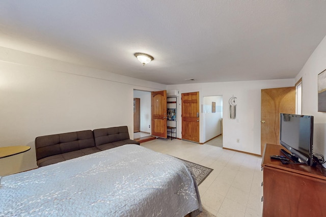 bedroom with baseboards and light floors