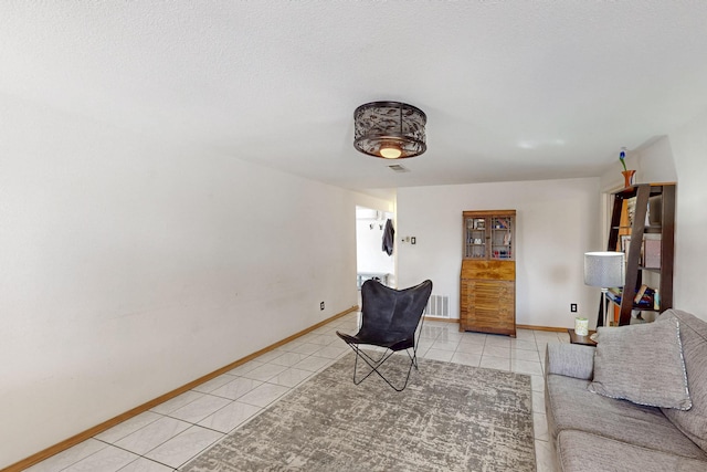 living room with light tile patterned floors, visible vents, and baseboards