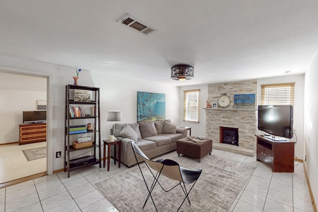 living area with light tile patterned floors, baseboards, and visible vents