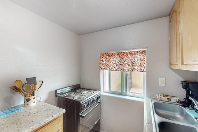 kitchen with light countertops, electric range oven, and a sink