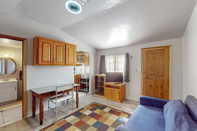 interior space with a sink, light wood-type flooring, and vaulted ceiling