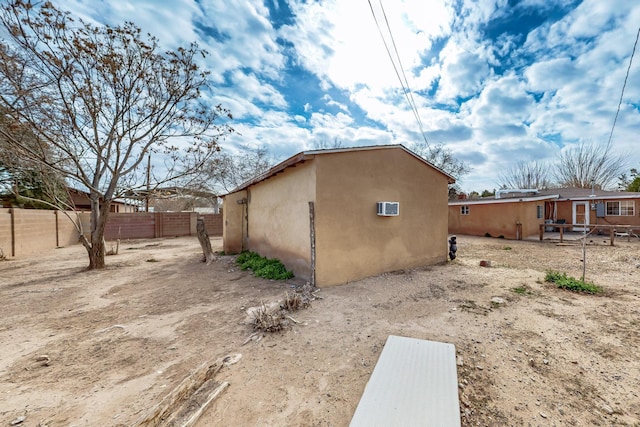 view of side of property featuring stucco siding and a fenced backyard