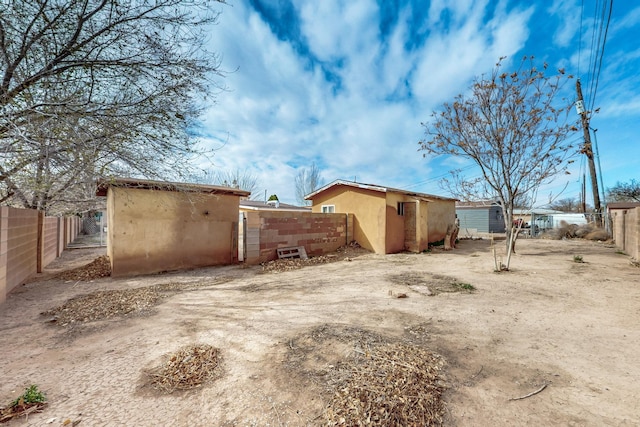 view of home's exterior with fence and stucco siding