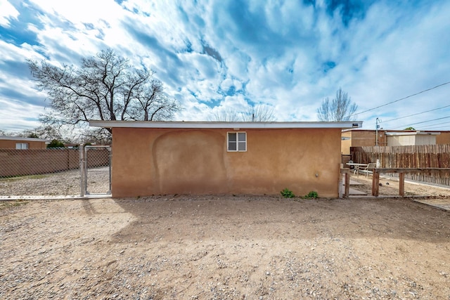 view of home's exterior with stucco siding and fence