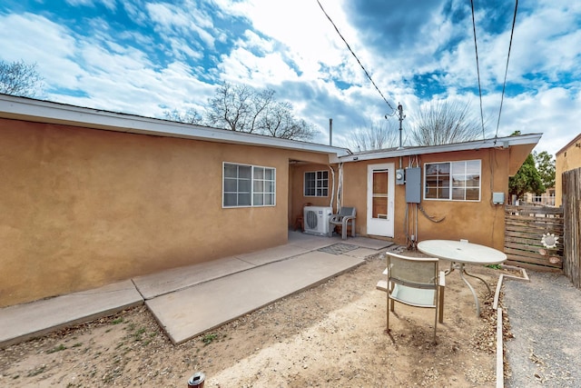 rear view of property with a patio, ac unit, fence, and stucco siding