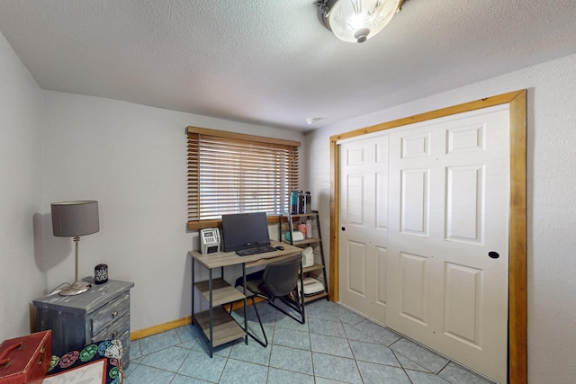 office with light tile patterned floors, a textured ceiling, and baseboards