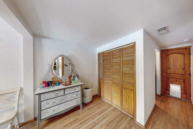 bedroom featuring a closet, visible vents, light wood-type flooring, and baseboards