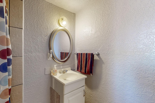 full bathroom with vanity, a shower with shower curtain, and a textured wall