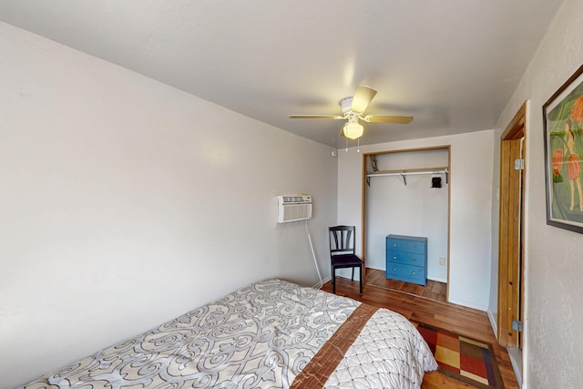 bedroom featuring a closet, a wall mounted air conditioner, ceiling fan, and wood finished floors