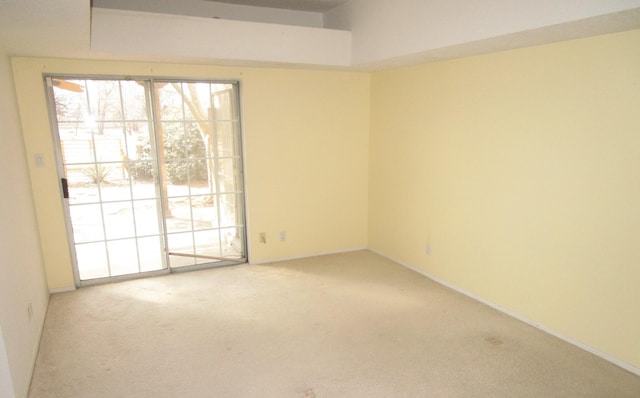 carpeted spare room featuring baseboards