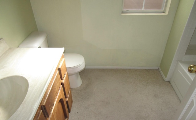 bathroom with baseboards, toilet, a bathing tub, carpet flooring, and vanity