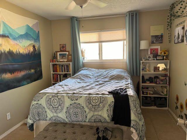 bedroom featuring tile patterned floors, a ceiling fan, and baseboards