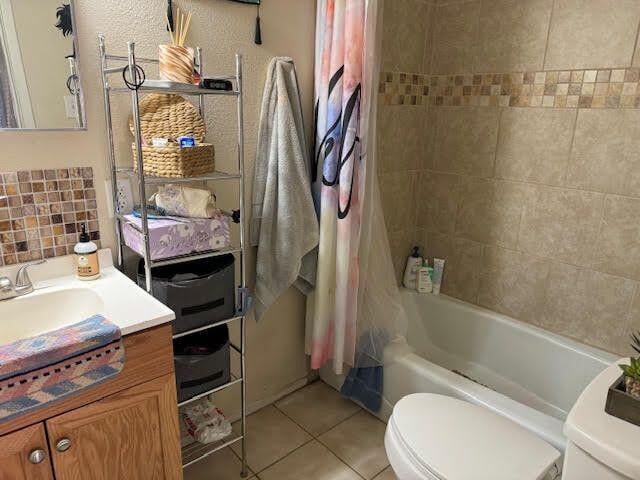 full bath with tile patterned flooring, toilet, vanity, and shower / bath combo with shower curtain