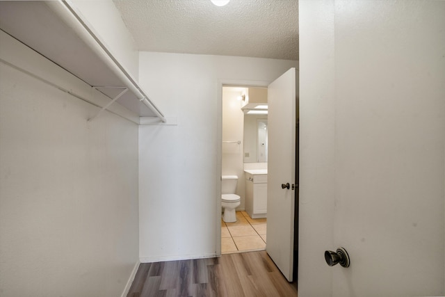 walk in closet with wood finished floors