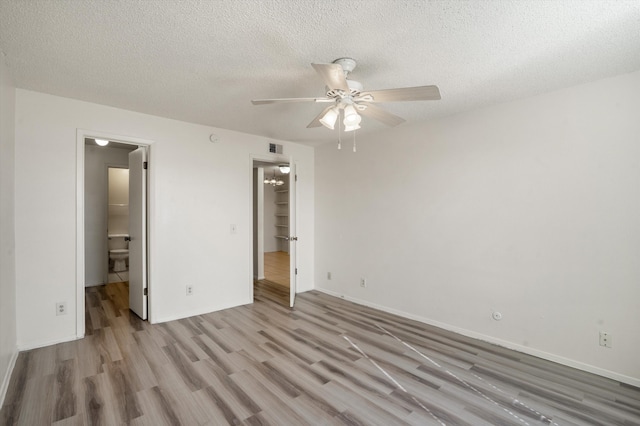 unfurnished bedroom featuring visible vents, baseboards, wood finished floors, a textured ceiling, and a ceiling fan