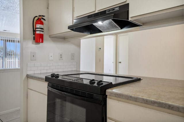 kitchen with under cabinet range hood, white cabinetry, a textured ceiling, and black range with electric stovetop