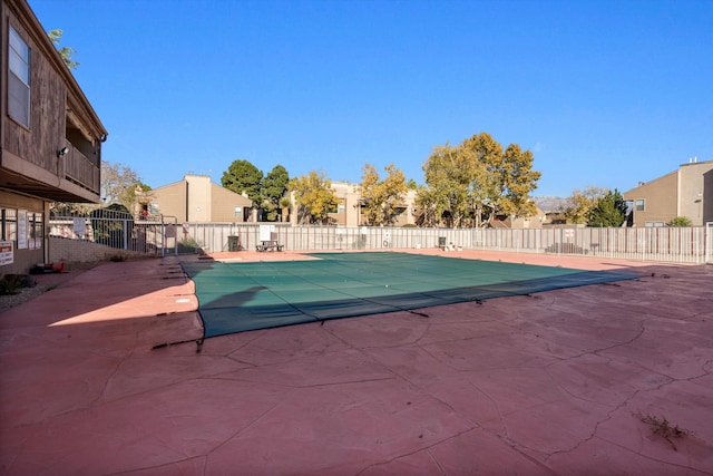 community pool with a patio area, a residential view, and fence