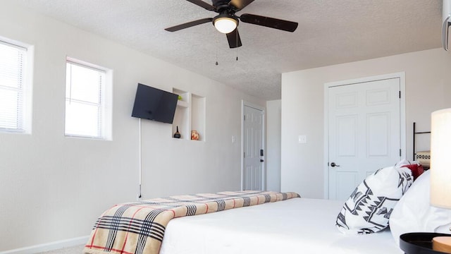 carpeted bedroom with baseboards, a textured ceiling, and a ceiling fan