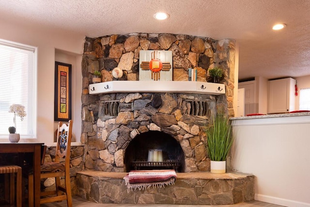 details with recessed lighting, a fireplace, a textured ceiling, and wood finished floors