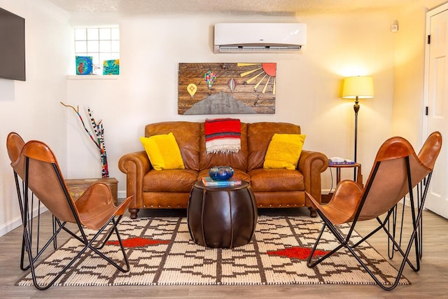 living area with wood finished floors, baseboards, and a wall mounted air conditioner