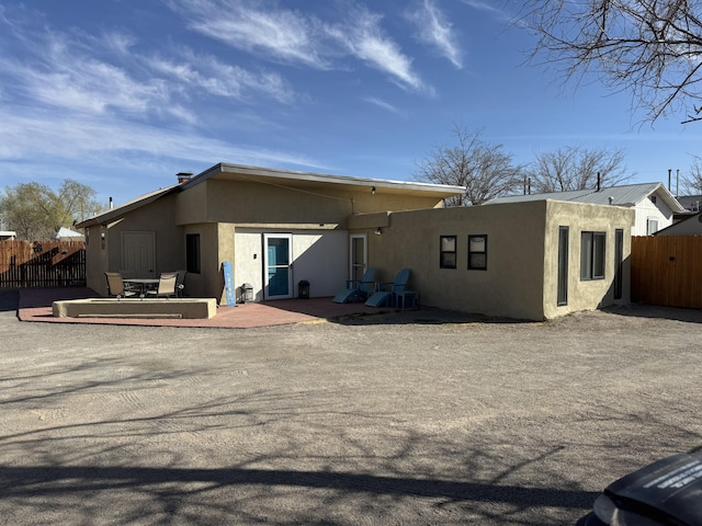 back of house featuring stucco siding, a patio area, and fence