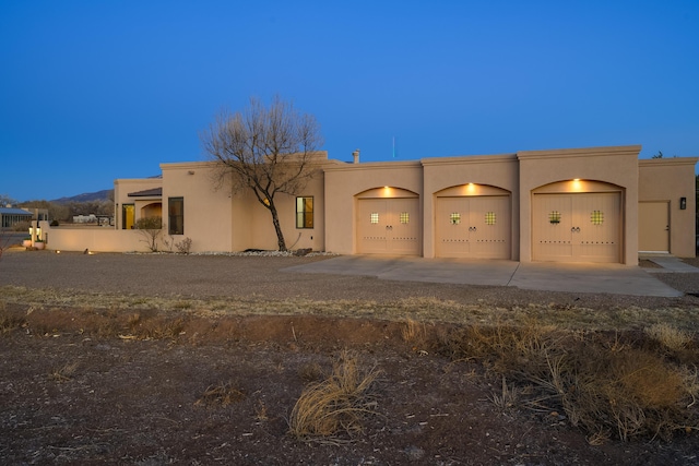 southwest-style home with stucco siding, an attached garage, and concrete driveway