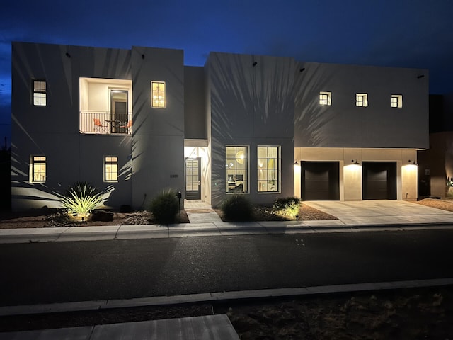 view of front of home featuring concrete driveway, an attached garage, and stucco siding