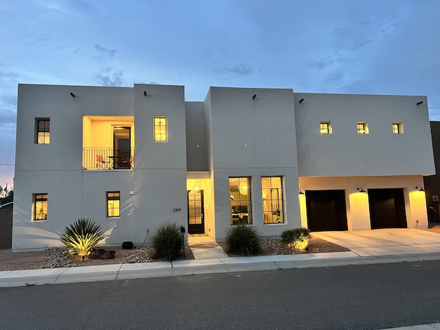 view of front of home with a garage, driveway, and stucco siding