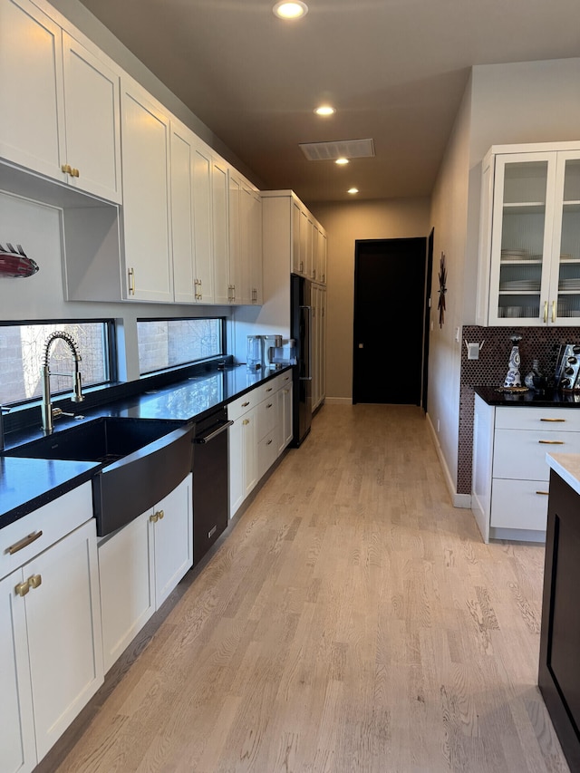 kitchen featuring light wood finished floors, white cabinets, and a sink