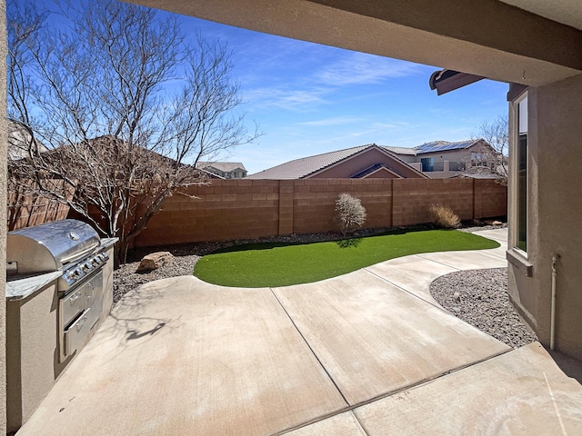 view of patio / terrace featuring a fenced backyard and exterior kitchen