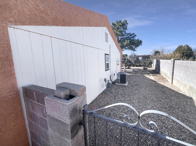 view of property exterior with fence private yard and central AC