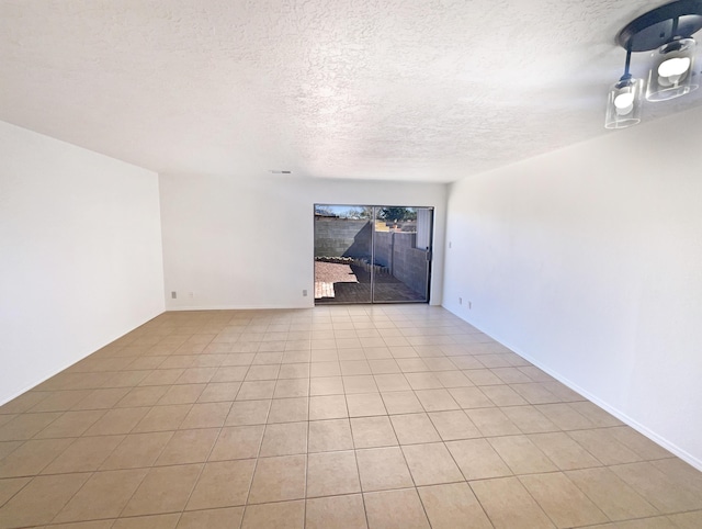 unfurnished room featuring light tile patterned floors and a textured ceiling