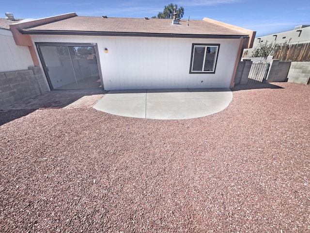 back of house featuring a patio, fence, and a shingled roof