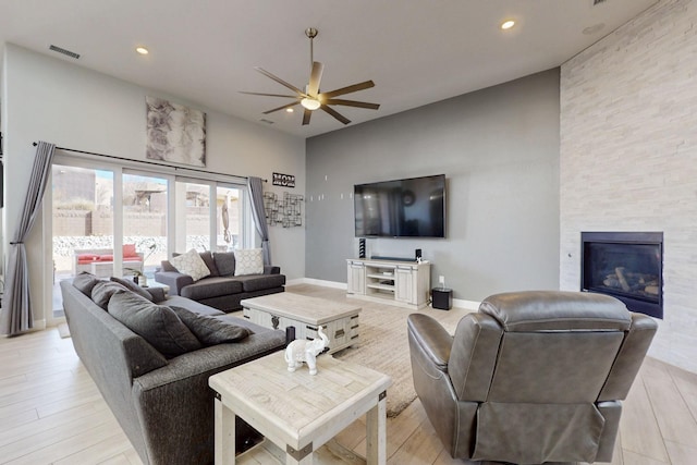 living area with a large fireplace, recessed lighting, visible vents, and ceiling fan