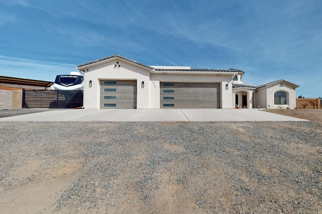 view of front of property featuring a tile roof, stucco siding, concrete driveway, and a garage